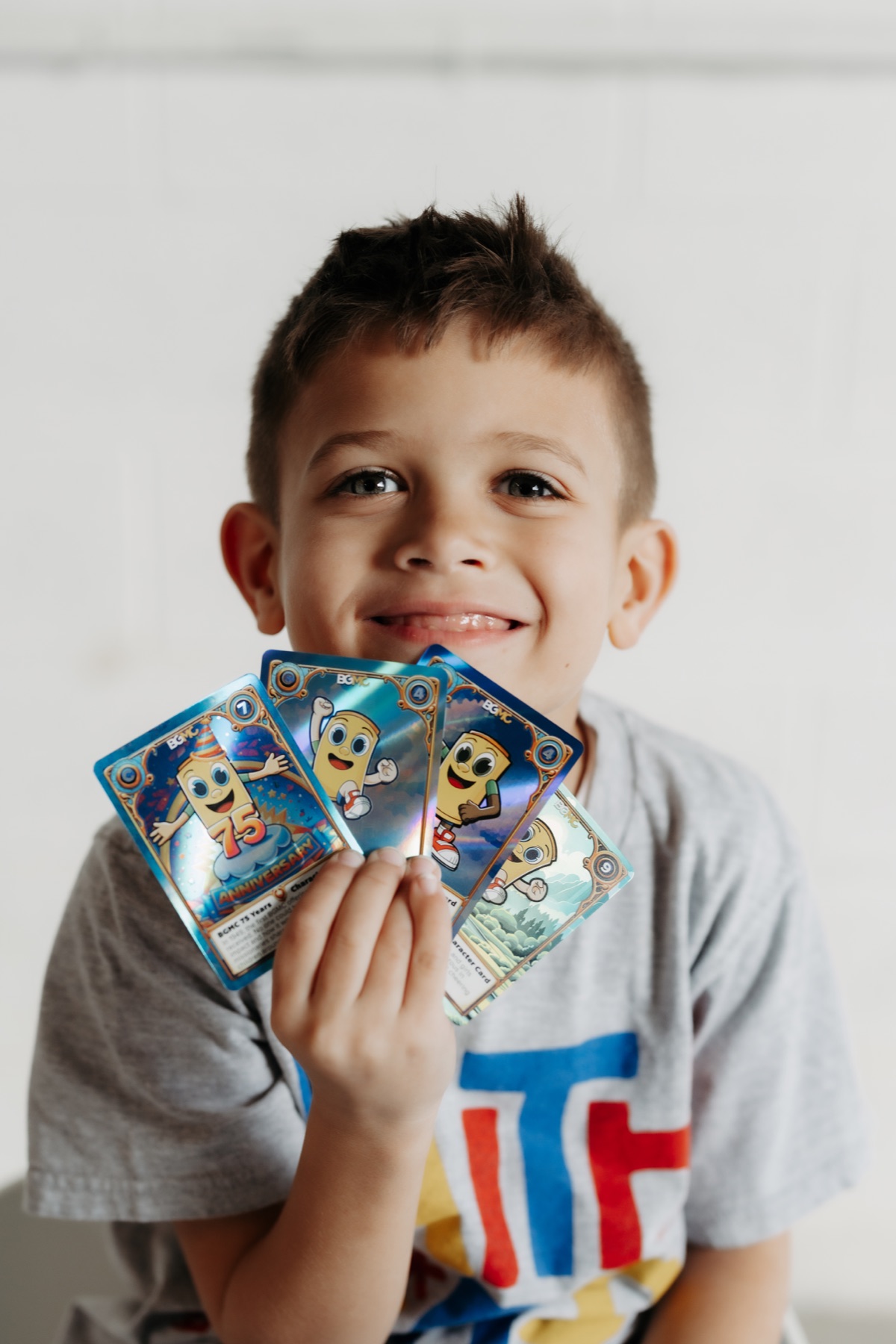 A smiling young collector holding his BGMC trading cards